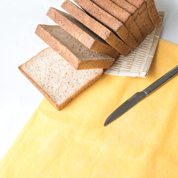High Angle View of Sliced Brown Wheat Sandwich Bread Loaf with Knife