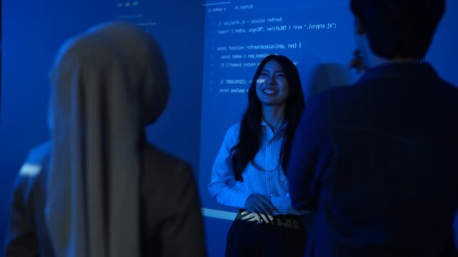 Asian female IT instructor presenting programming code on screens, Smiling tech speaker teaching software development to students, Coding education and corporate technology training seminar concepts