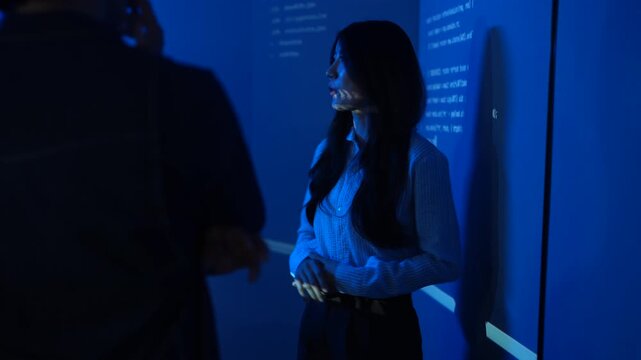 Asian female IT instructor presenting programming code on screens, Smiling tech speaker teaching software development to students, Coding education and corporate technology training seminar concepts