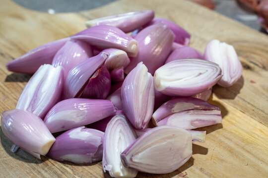 Stockholm, Sweden Peeled shallots or onions on a wooden board.