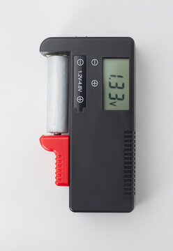Digital battery tester device with LCD screen showing voltage isolated on white background