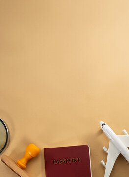 Travel concept flat lay with passport toy airplane and stamp on beige background with copy space