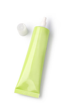 Unlabeled lime green skincare cream tube with detached cap on white background