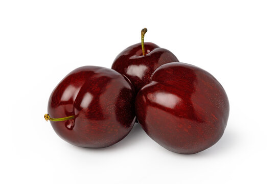 Three red plums clustered on a white background