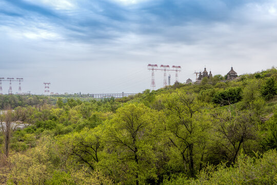 Historic Cossack fortress surrounded by green spring forest and power lines in Zaporizhzhia, Ukraine