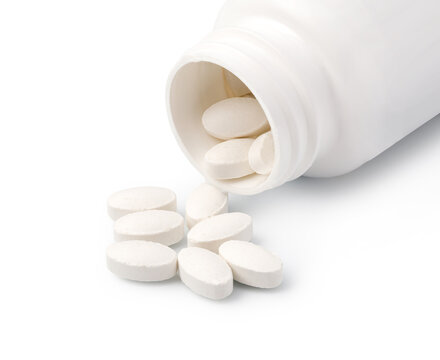 White tablets spilling from an open pharmaceutical bottle