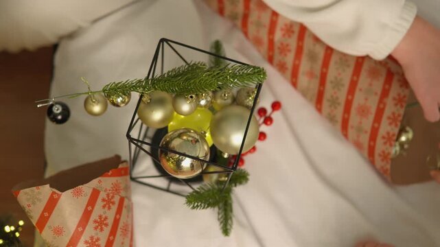 Warm holiday footage features a young boy who reaches toward a lantern display filled with Christmas ornaments. This candid family scene illustrates safe exploration, holiday wonder and togetherness.