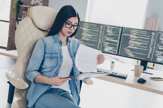 Portrait of attractive concentrated girl top leader hr director tech lawyer assistant reading resume cv at workplace workstation indoors