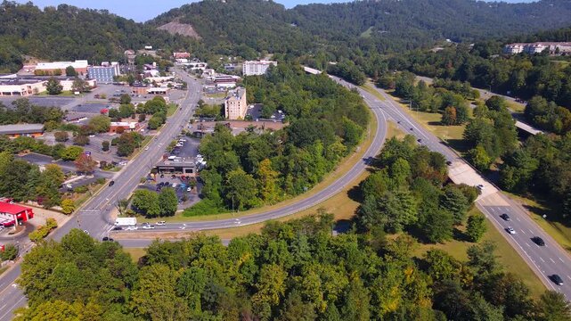A curved ramp connects roadside development with a divided Asheville highway.