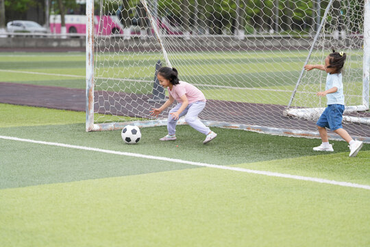 Children Playing Soccer at a Sports Field in the Afternoon