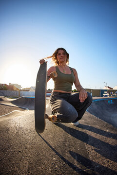 Skater poses at skate park during sunset