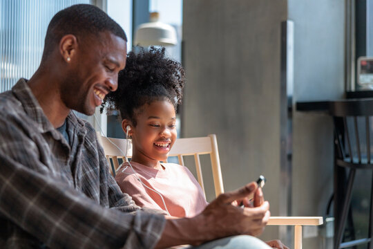 Girl and her father watch media content via phone