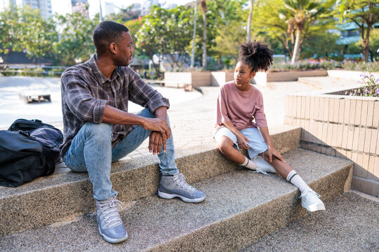 Father and daughter enjoy a conversation outside.