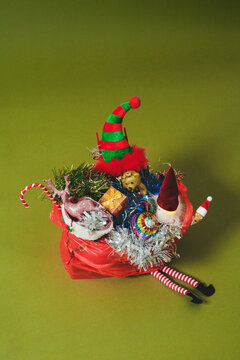 an overflowing bag of Christmas decorations on a green background