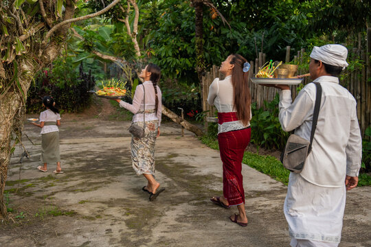Balinese Family Carries Offerings in a Garden Setting