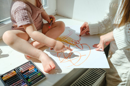 Mother and child drawing together with colorful pastels
