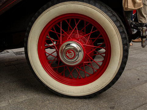 GANDIA, SPAIN - OCTOBER 4, 2026: Red wire-spoke wheel with whitewall tire and chrome hubcap on a vintage 1931 Chrysler CM6 automobile.