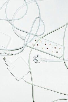 White technology tech wires, cords and charges in office with flashlig