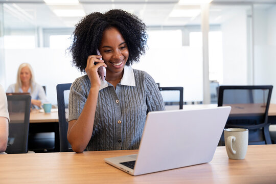 Young business woman communicating on phone in office