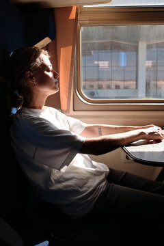 Woman gazing out train window enjoying view from compartment