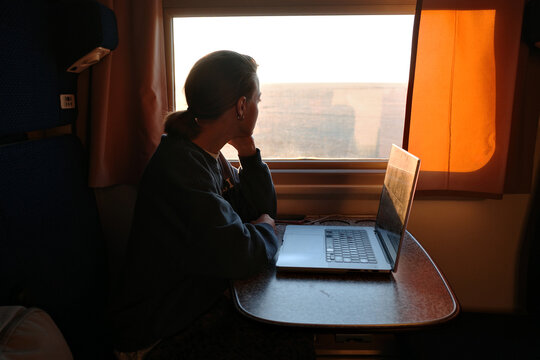 Woman working on laptop while traveling on train