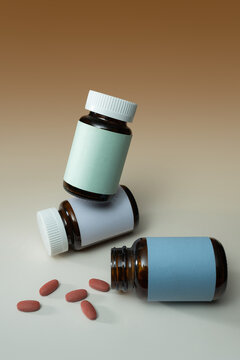 Three amber medicine bottles with blank labels and scattered pills