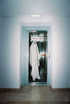 inside an open elevator, a ghost pushes a control button, 35mm film