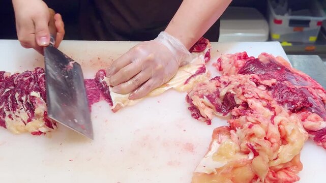 Chef Hands in Gloves Thinly Slicing Premium Beef on White Professional Surface &ndash; Preparing Thin Translucent Meat Layers for Gourmet Dish