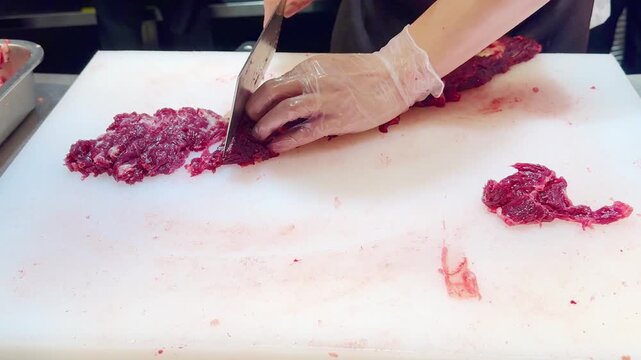 Chef Hands in Gloves Thinly Slicing Premium Beef on White Professional Surface &ndash; Preparing Thin Translucent Meat Layers for Gourmet Dish