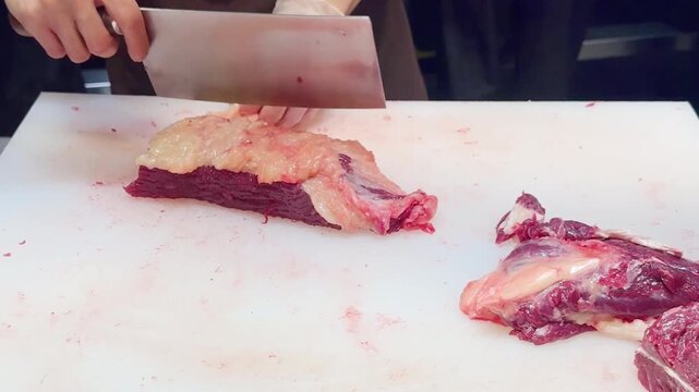 Chef Hands in Gloves Thinly Slicing Premium Beef on White Professional Surface &ndash; Preparing Thin Translucent Meat Layers for Gourmet Dish