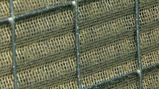 Repeating Metal Grid Pattern on Industrial Equipment. Close industrial footage emphasizes repeating metal fins, grids, pipes and structural frame details without claiming a specific function.