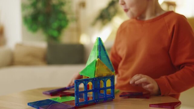 Curious child plays with colorful construction toy blocks, improving logic