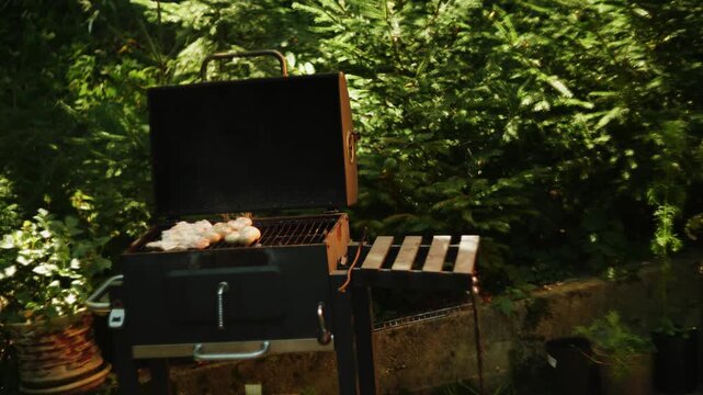 Outdoor barbecue grilling food on backyard grill during sunny daytime