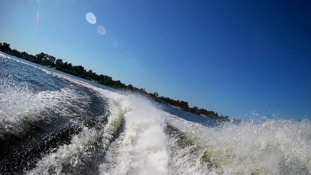 Rear pov view of a fast jet ski moving on river creating dynamic water splashes
