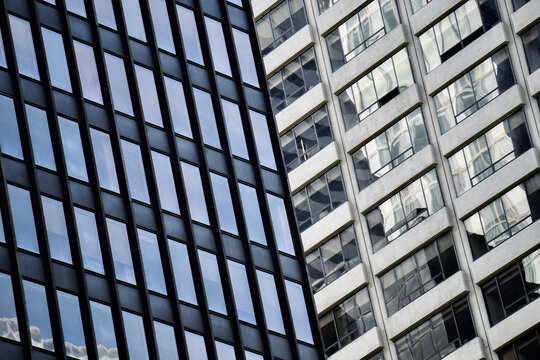 Black glass grid tower against a white grid facade