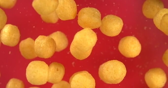 Cheese balls falling in slow motion 1000 fps on red background