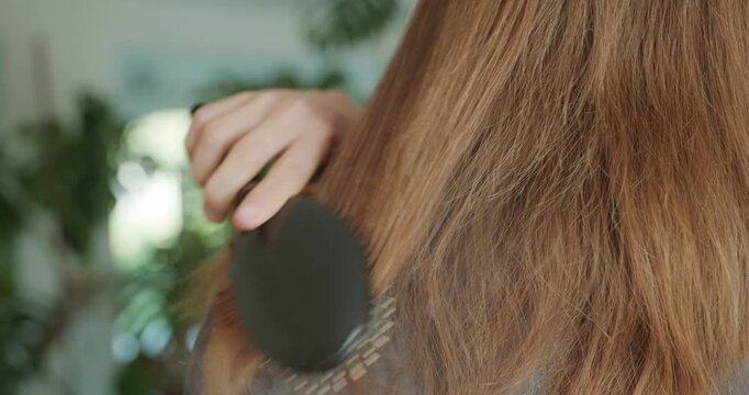 Close-up male hand is combing long hair with a comb. 4K 10-bit