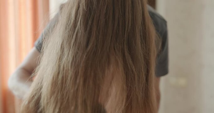 Close-up male hand is combing long hair with a comb. 4K 10-bit