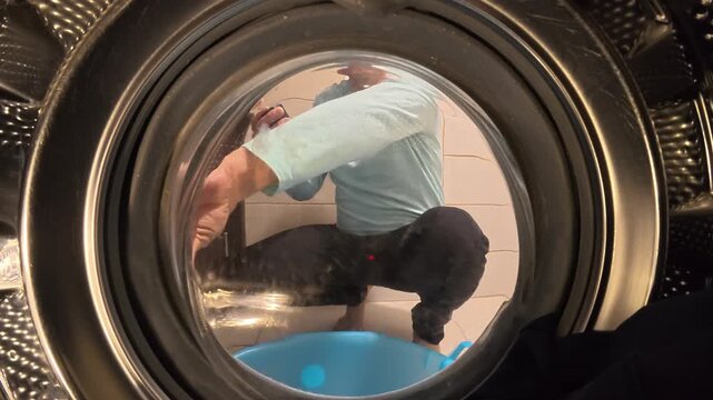 Man Opening Washing Machine Door from Inside Drum