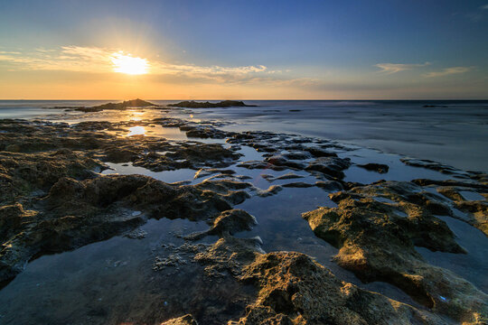Golden sunset light over a rugged rocky sea coast