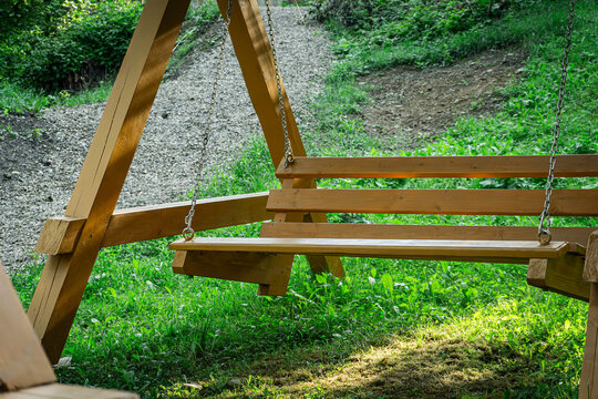 Wooden swing hanging on metal chains