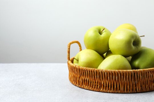 Red apples in a woven basket on the table