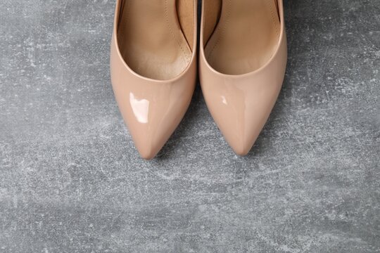 Stylish classic women's beige high heel shoes on grey background. Top view, flat lay