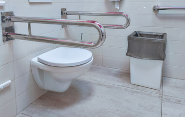 Plakat Accessible toilet with wall mounted grab bars in tiled bathroom. Universal design for mobility and independent living. Public restroom accessibility and disability inclusion