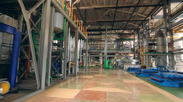 Manufacturing plant hall walkthrough. Blue machinery steel pipes tanks catwalk.