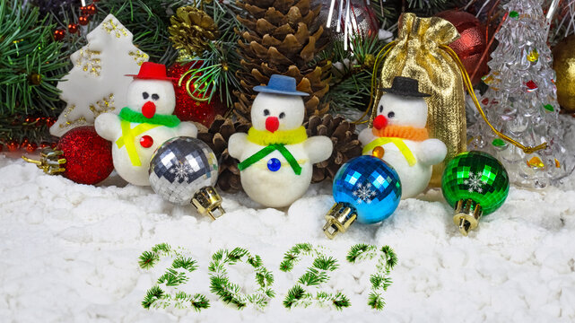 Snowman figures and ornaments arranged under a Christmas tree for the holiday season