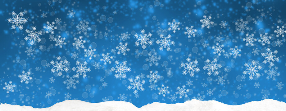 Snowflakes fall across a blue winter sky above a layer of snow