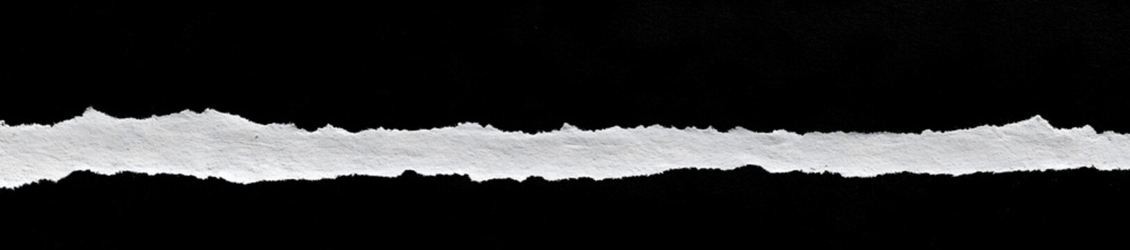 Torn edges of a crumpled sheet isolated against a black backdrop