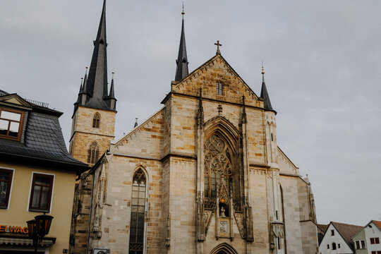 Gothic stone church with pointed spires and tracery window