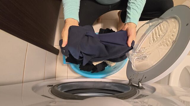 Overhead Hands Spreading Clothes and Closing Washer Door
